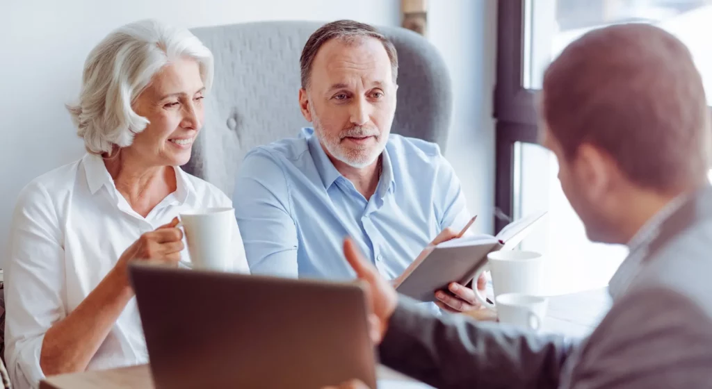 Couple de seniors échangeant avec un conseiller en prévoyance obsèques.