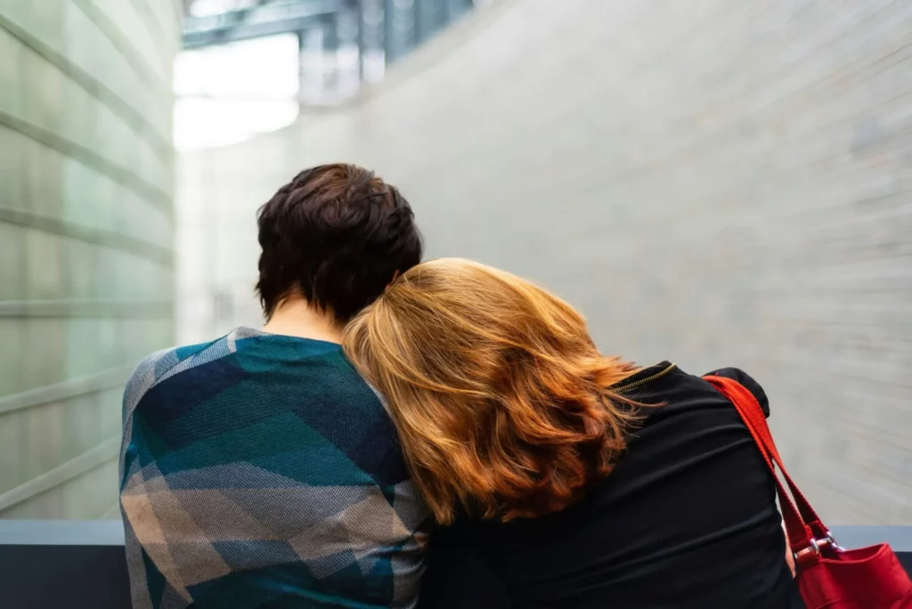 Femme posant sa tête sur l'épaule de son amie pour la réconforter.